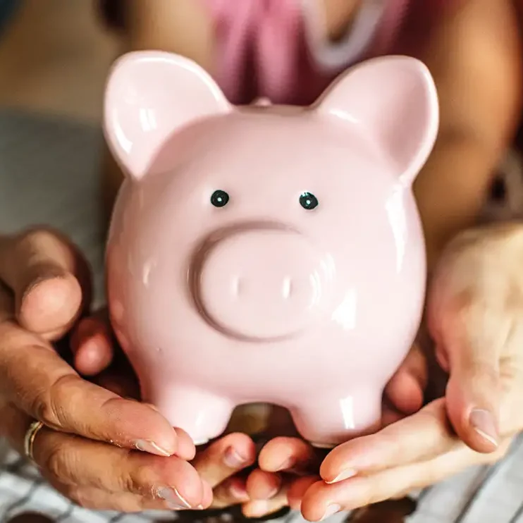 Sparschwein auf Hände Hände halten eine rosa Sparschweinchen.